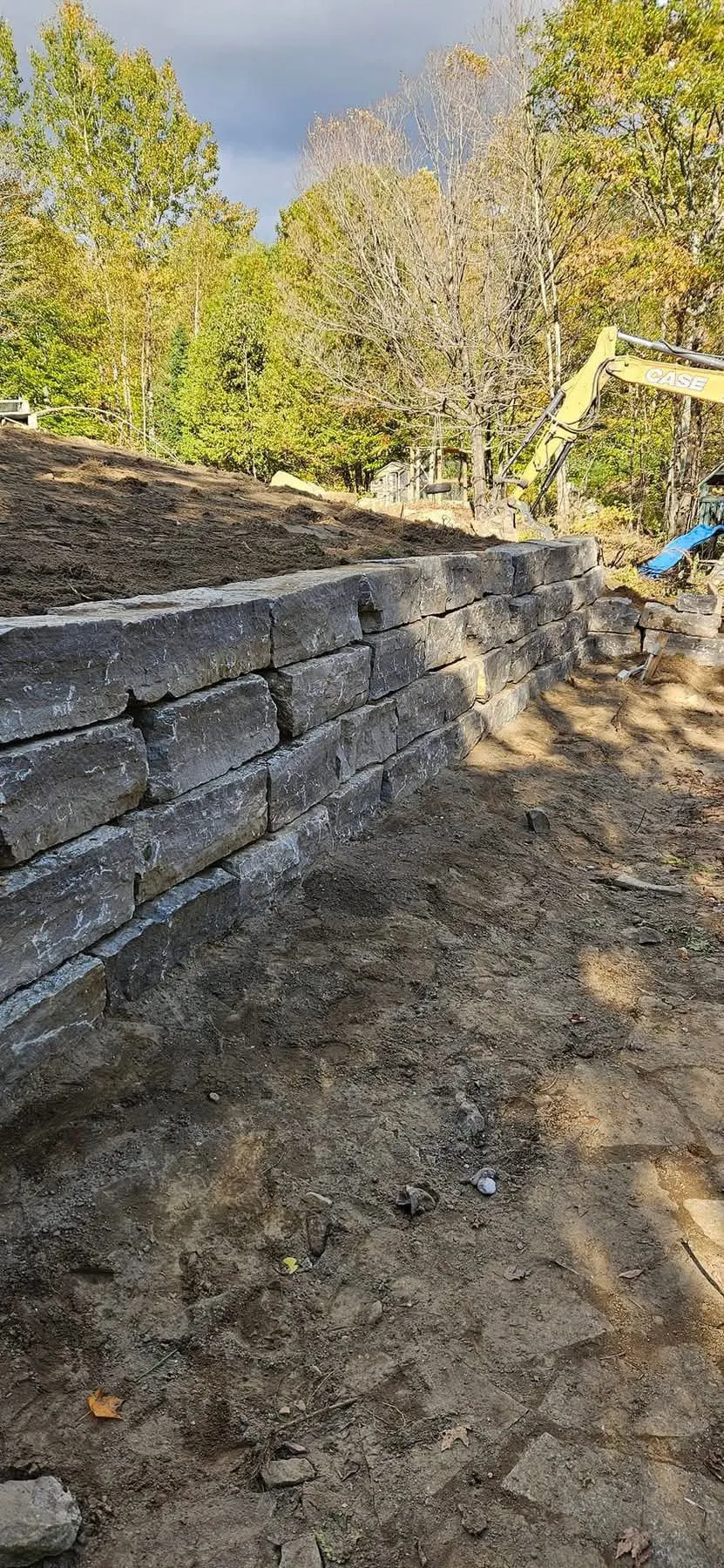 Muret de soutènement en pierre naturelle dans un boisé