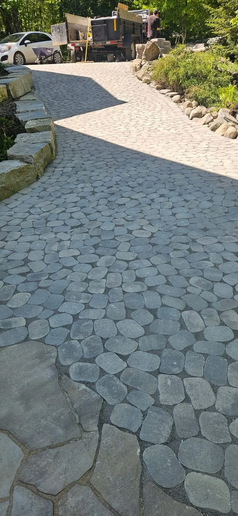 Allée de pavé uni avec murets de pierre en bordure