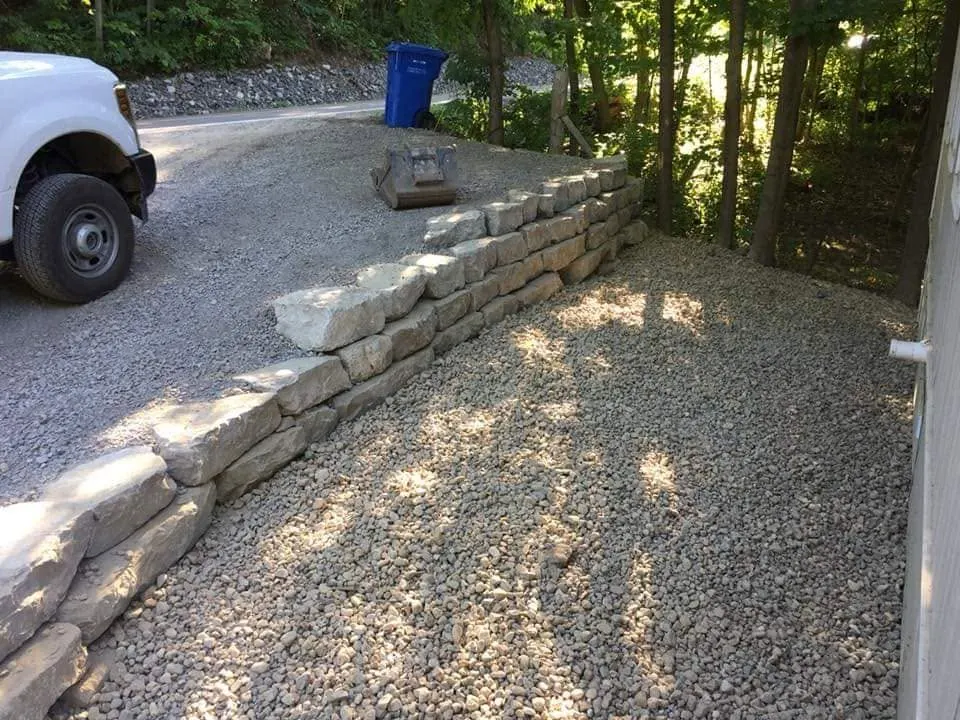 Muret de soutènement en pierre le long d’une entrée de gravier