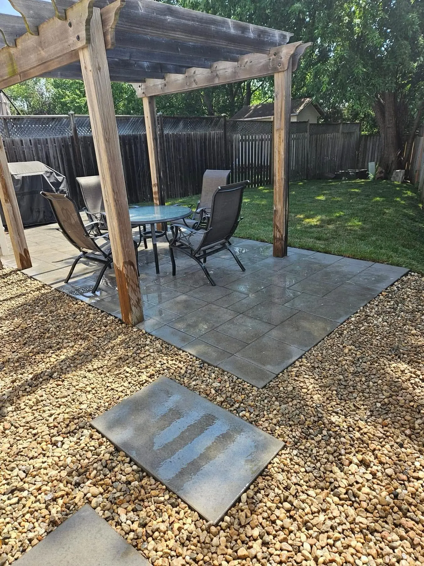 Patio de pavé uni sous une pergola en bois