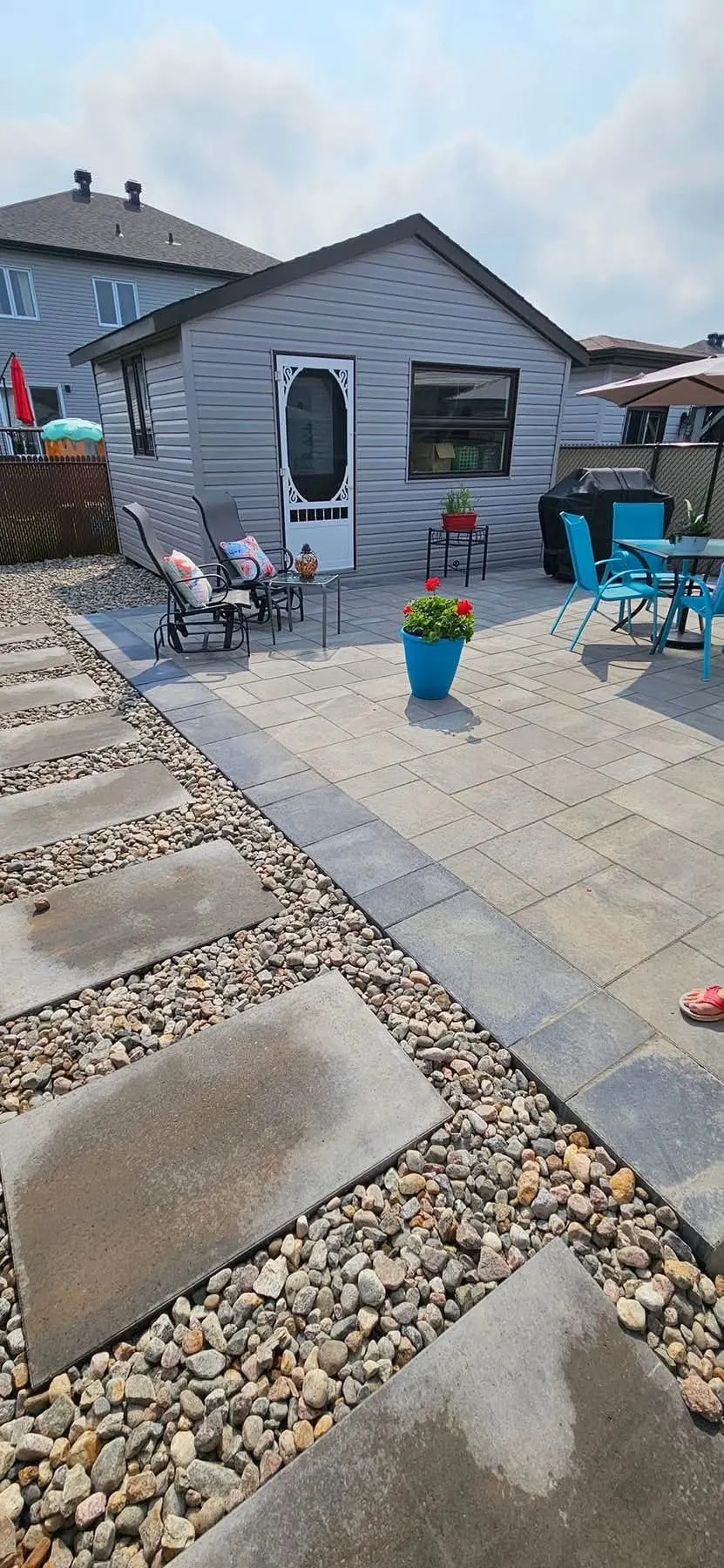 Patio de pavé uni avec bordure de gravier
